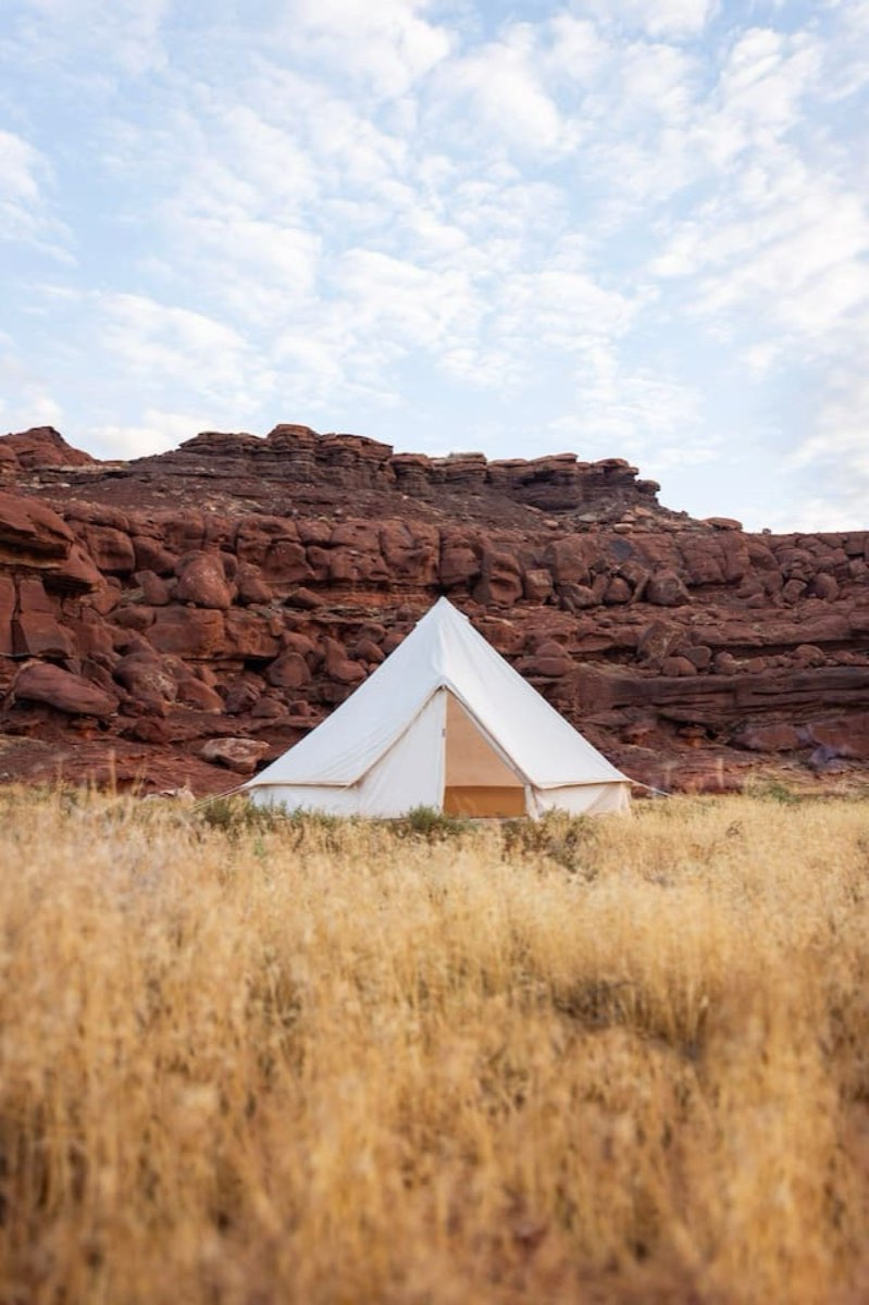 A canvas bell tent pitched against the red rock