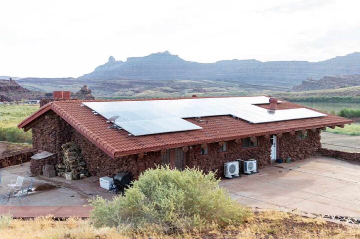 The Ranch House from outside, stone walls and solar panels on the roof