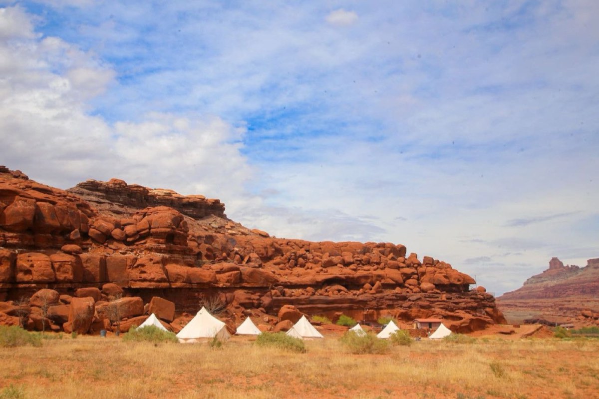 Canvas tents beneath the red cliffs